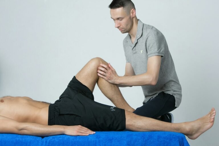 Physiotherapist assessing a patient's knee on a treatment table